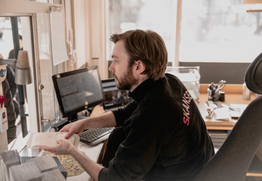 En Seko-medlem på Skansen lämnar ut ett kvitto till en besökare som köpt något.