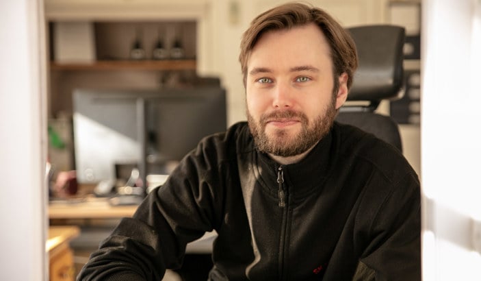 En Seko-medlem som jobbar på Skansen tittar ut från en biljettlucka och in i kameran.