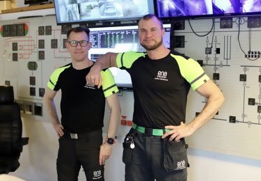 Två manliga Seko-medlemmar på energi i arbetskläder. de ene hänger på den andres axel.