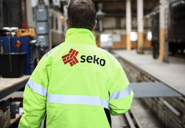 Person med varseljacka som tittar ut över en verksatad