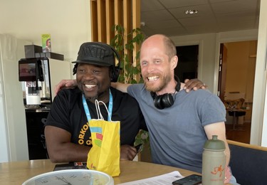 Två Seko-medlemmar på PostNord sitter och håller om varandras axlar.