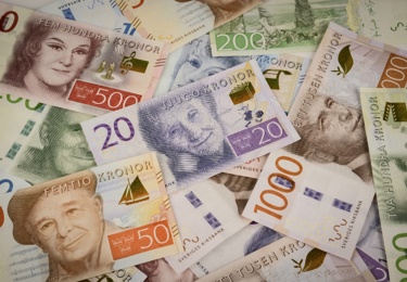 Svenska sedlar ligger i en stökig hög, överst en tjugolapp.