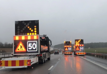 Tre TMA-bilar på motorväg i regn.