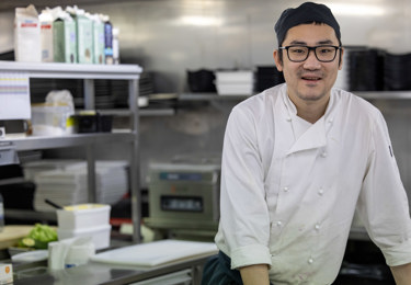 Medlem som jobbar i kök på färja tittar upp från sitt arbete och in i kameran.