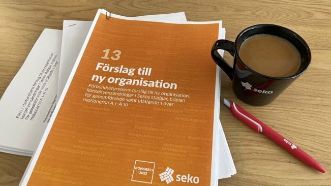 En rapport (hög med papper) som handlar om Sekos organisationsutredning