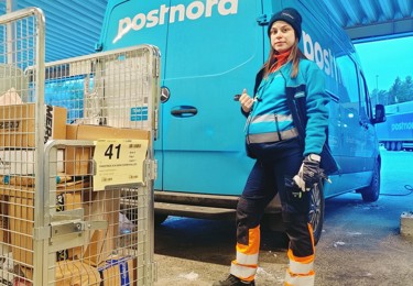 En chaufför i PostNorduniform framför en skåpbil